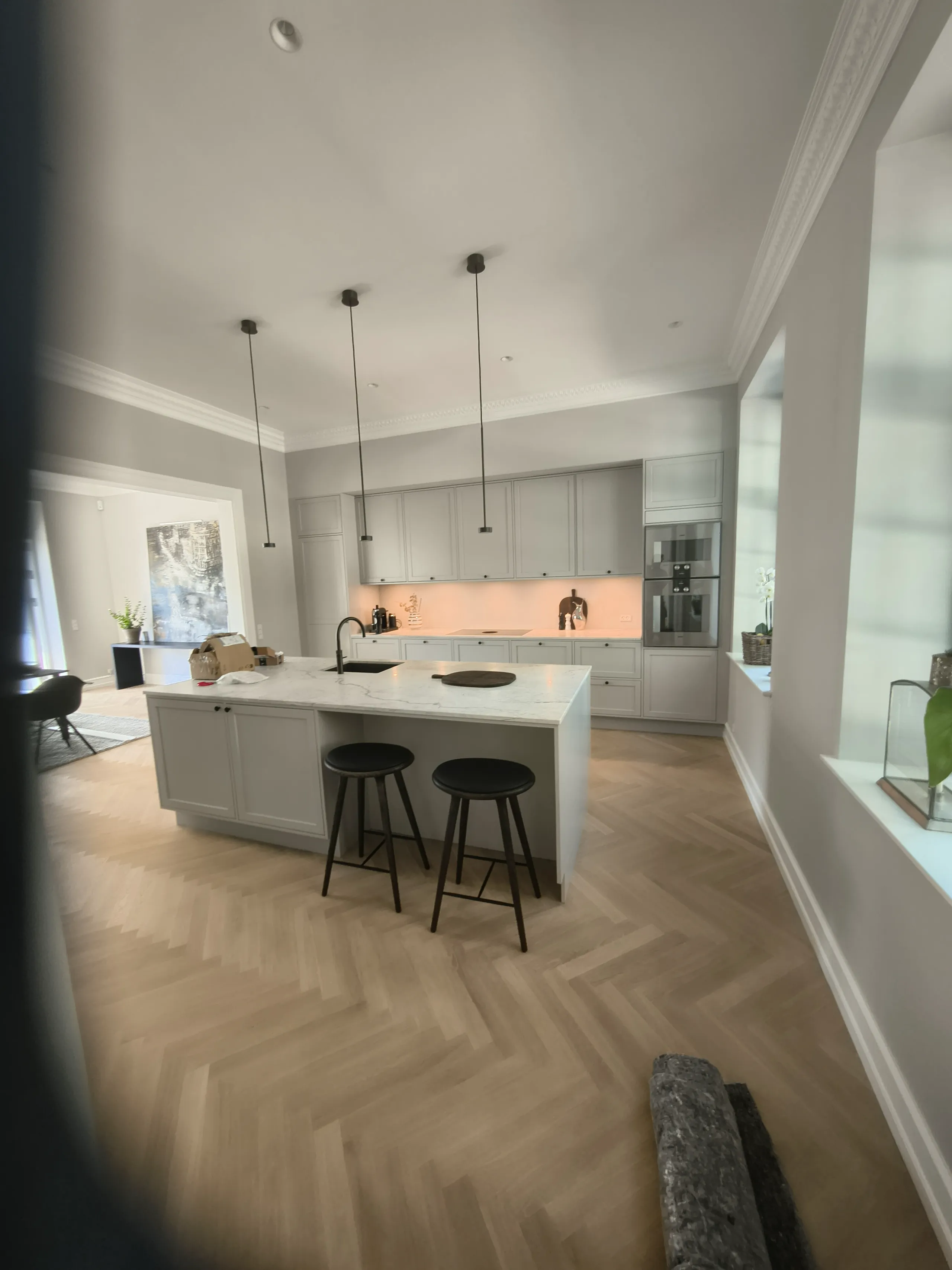 Moderne hvidt køkken med central ø og pendant lamper