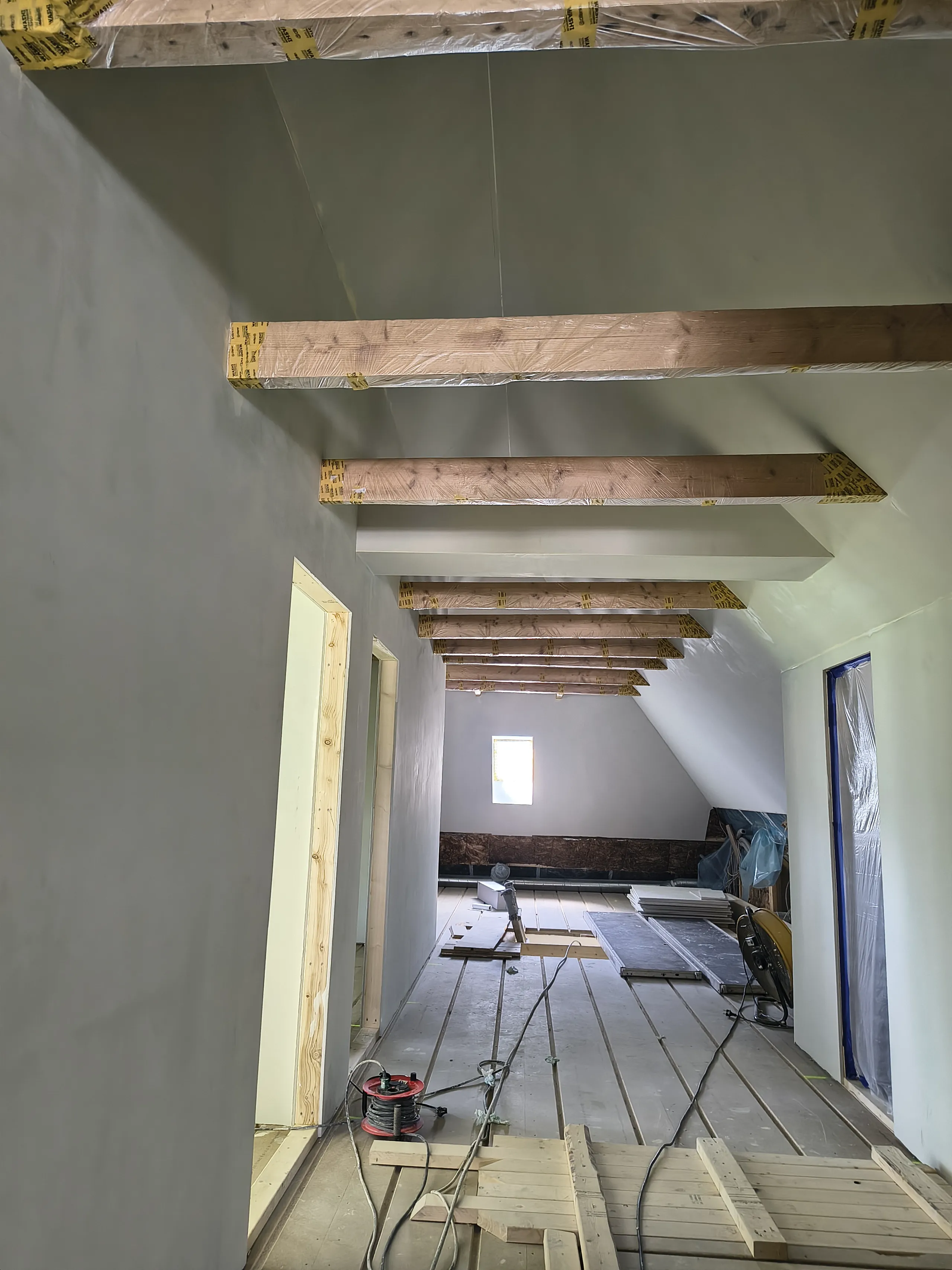 Rum under renovering med eksponerede træbjælker