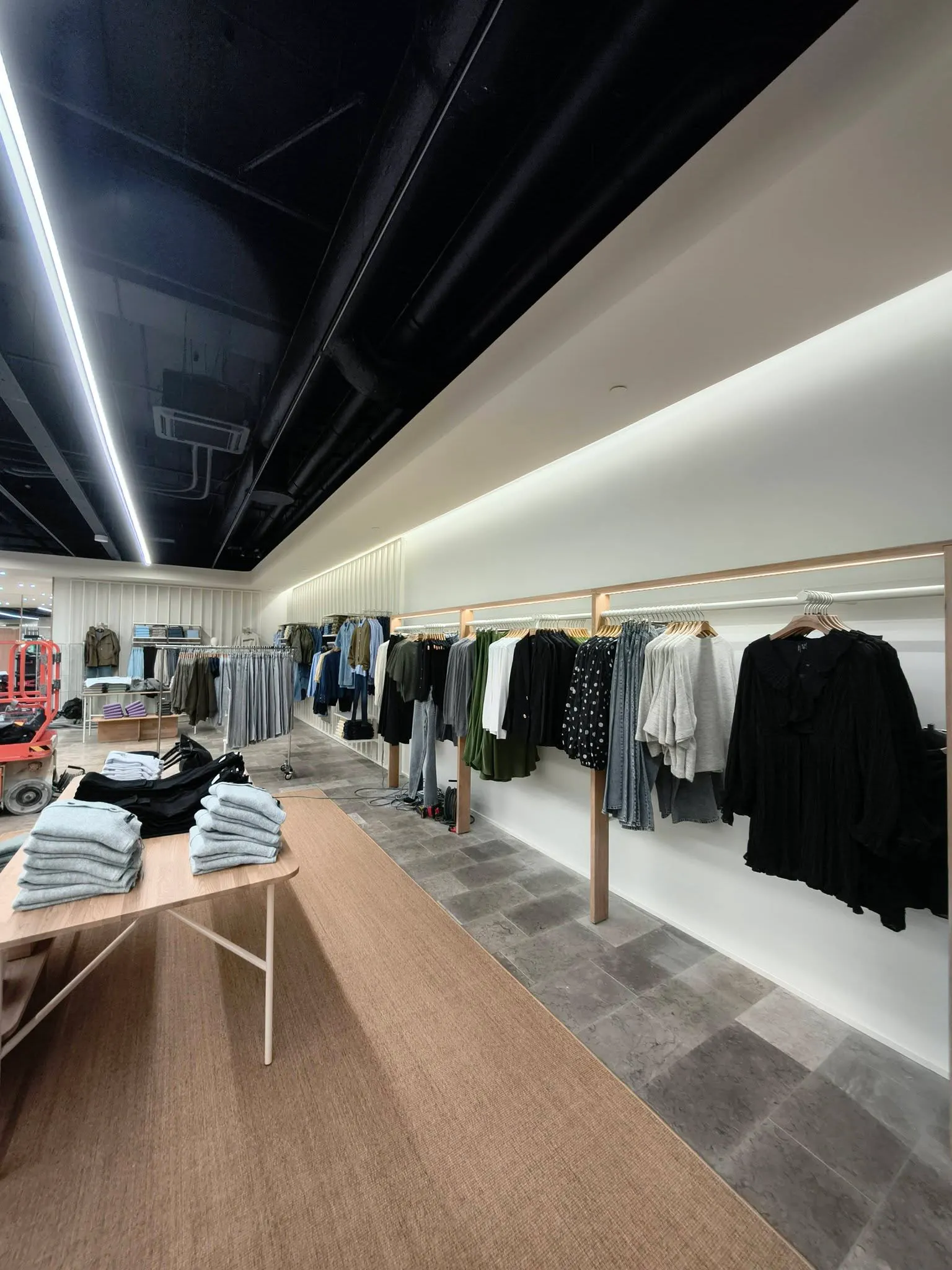 Indvendig malerarbejde i en moderne butik med tøjpræsentation