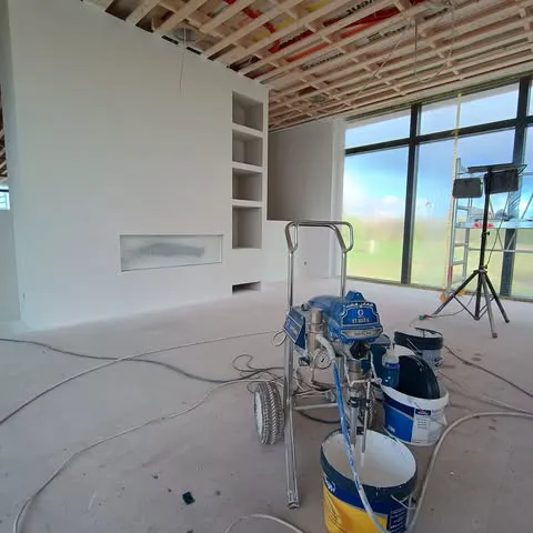 Indvendig malerarbejde med sprøjtemaling af vægge og loft i moderne rum