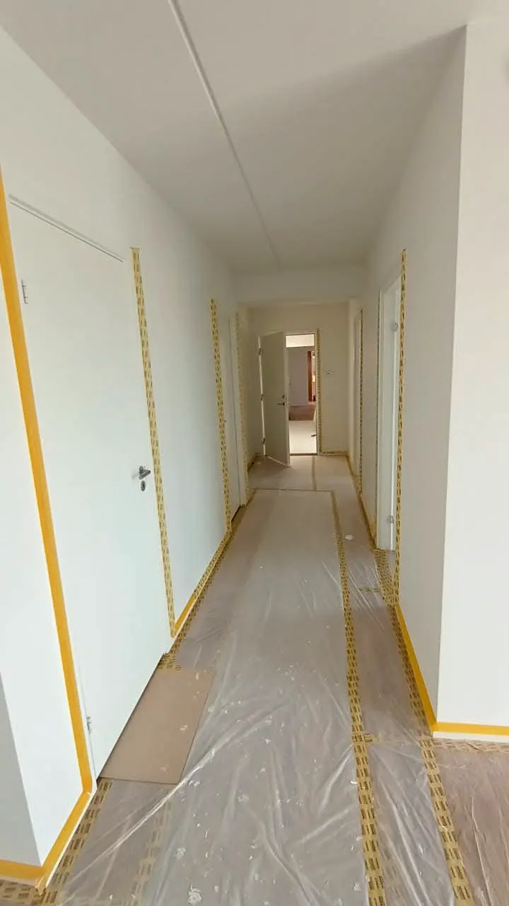 Nyhvidmalede vægge og lofter i en gang, klar til indvendig renovering